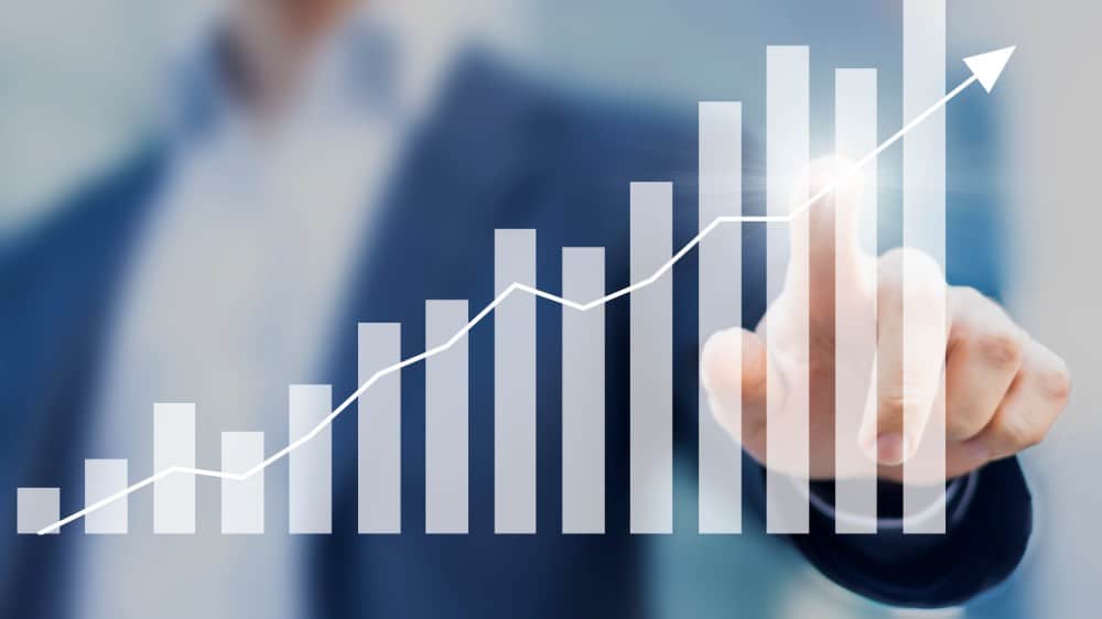 Business success with growing rising charts and businessman in background 3 Under-$10 Growth Stocks to Buy Right Now