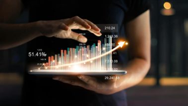Businessman holding tablet and showing a growing virtual hologram of statistics graph and chart with arrow up on dark background. Stock market. Business growth planning and strategy concept Air Canada (TSX:AC) and Cineplex (TSX:CGX) Could Surge in Summer