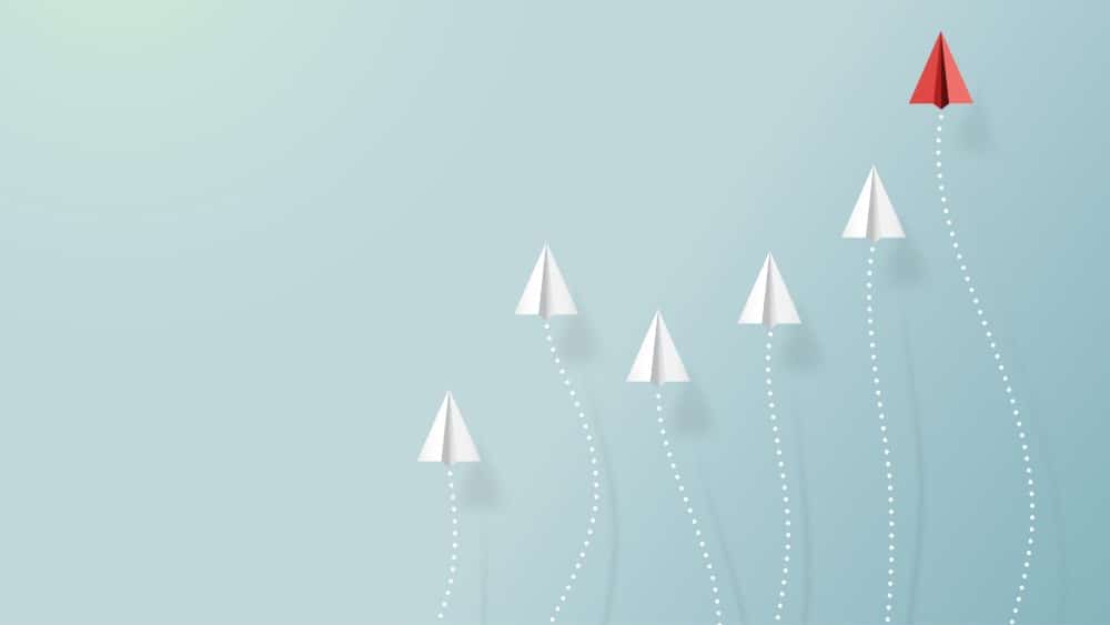 Paper airplanes flying on blue sky with form of growing graph Why Cheap Stocks Are Beating Tech Stocks in 2022