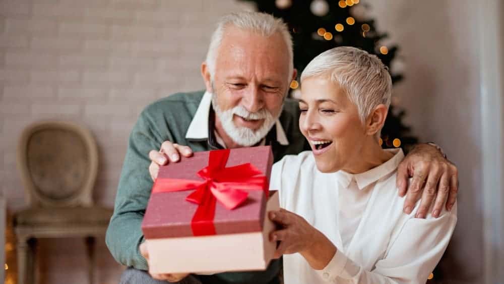 Elderly man giving a Christmas present to his wife1 3 Canadian Dividend Stocks I’d Buy This Christmas