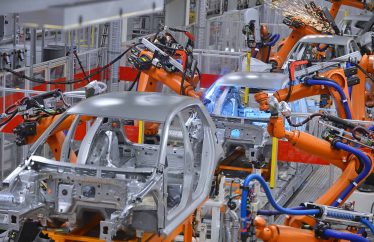 robotic arms assembling cars in a factory Trudeau Declares War on EV Tax Credits: the Takeaway for Investors
