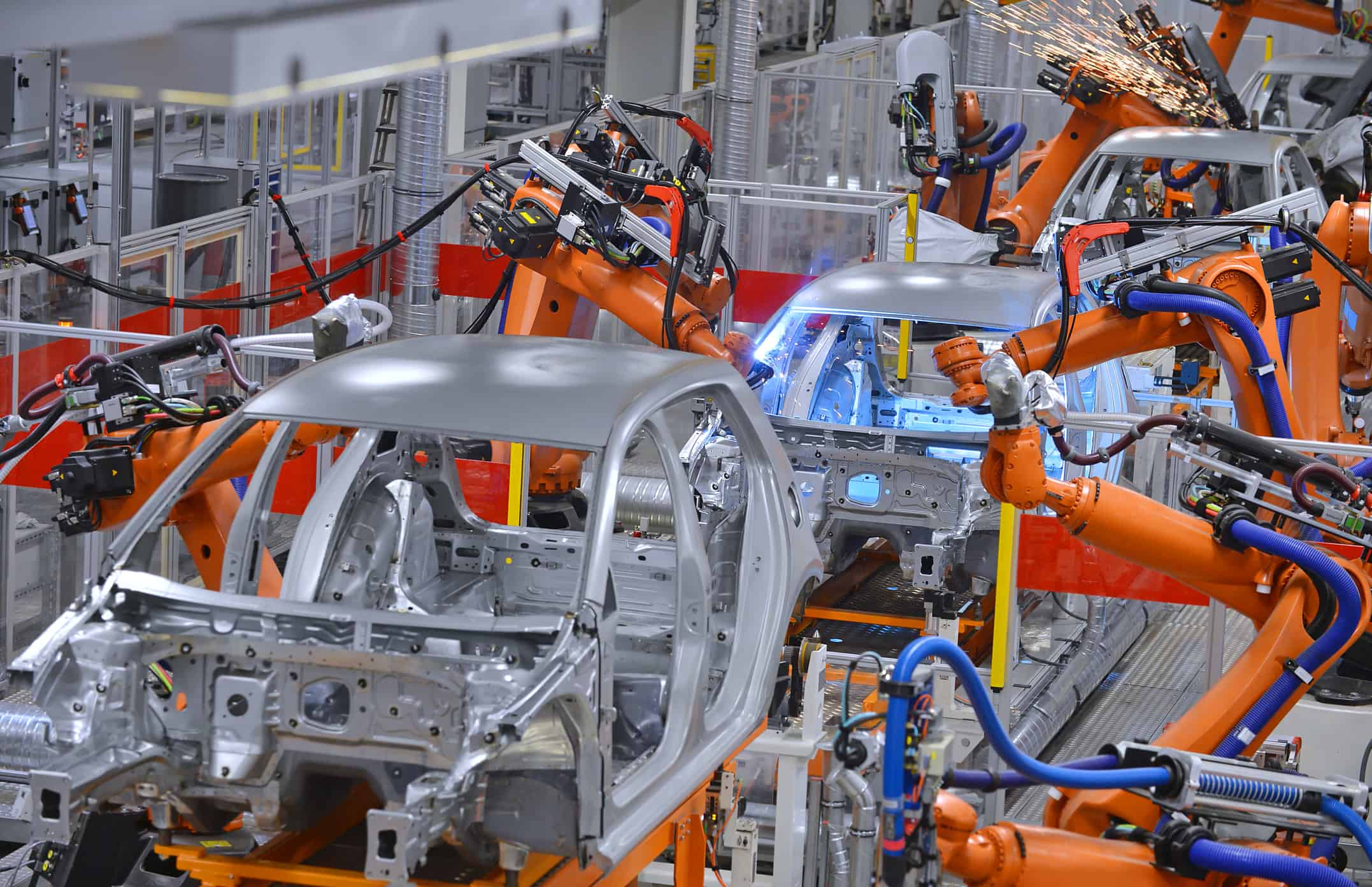 robotic arms assembling cars in a factory Trudeau Declares War on EV Tax Credits: the Takeaway for Investors